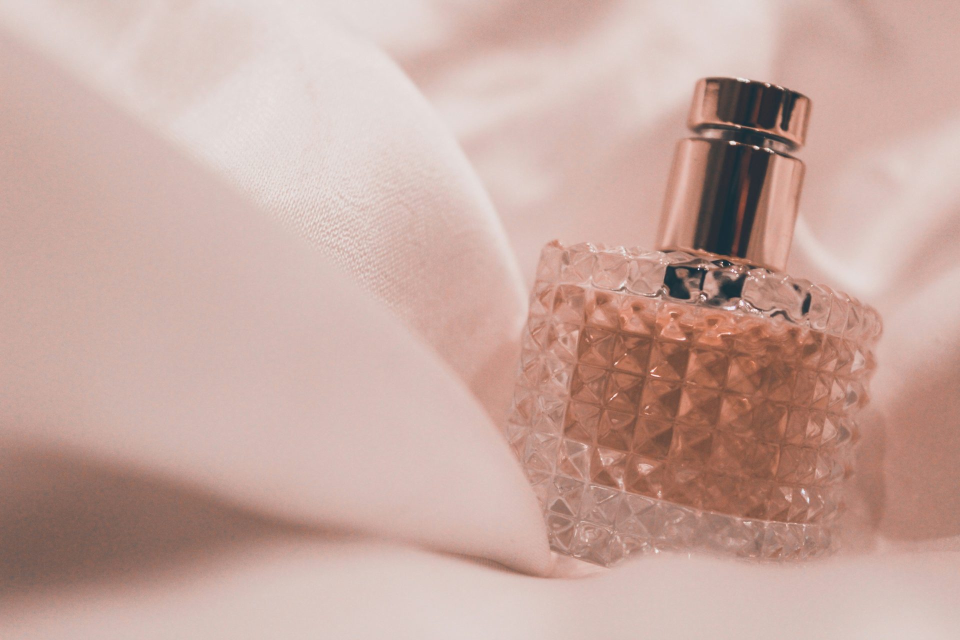 Crystal perfume bottle on soft fabric background