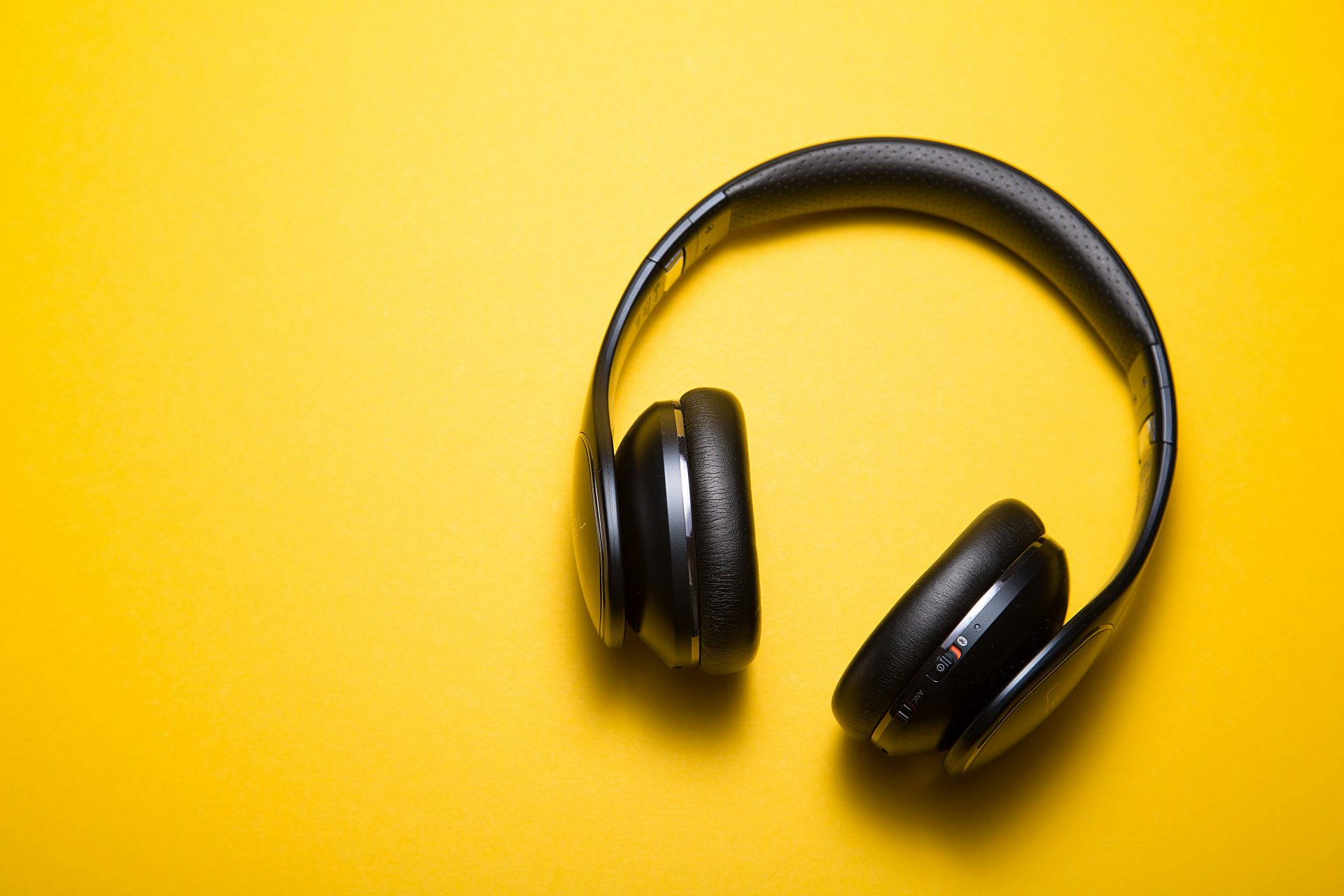 Black headphones on a vibrant yellow background